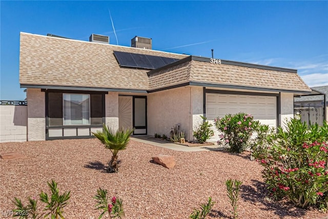 3748 Silent Hill Dr, Las Vegas, NV 89147 - view of front of house with roof with shingles, roof mounted solar panels, a garage, and stucco siding