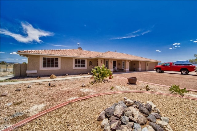 3251 S Parkridge Ave, Pahrump, NV 89048 - view of front of property with a garage, driveway, stucco siding, and a tile roof
