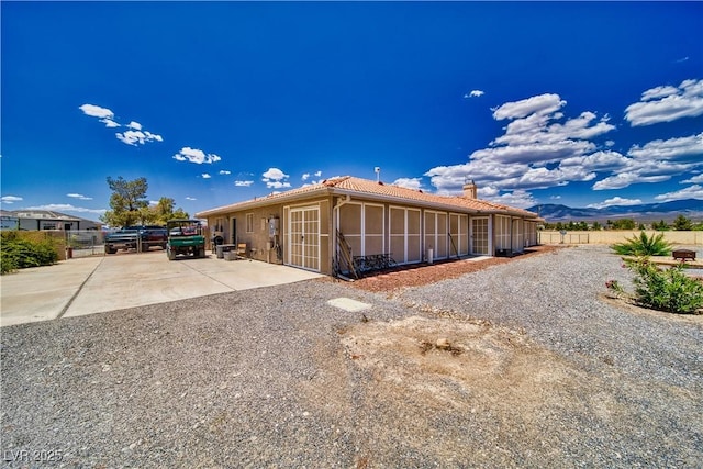 3251 S Parkridge Ave, Pahrump, NV 89048 - view of side of property with a chimney, a tile roof, and stucco siding