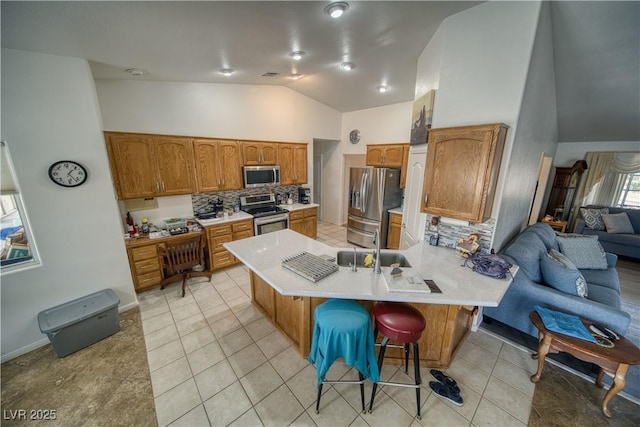 3251 S Parkridge Ave, Pahrump, NV 89048 - kitchen with stainless steel appliances, a peninsula, backsplash, a kitchen breakfast bar, and light countertops