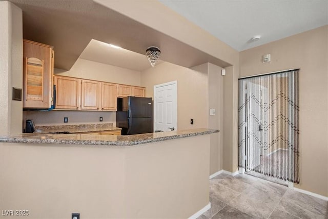 5855 Valley Dr Unit 2130, North Las Vegas, NV 89031 - kitchen with freestanding refrigerator, light brown cabinets, light stone counters, a peninsula, and light tile patterned floors