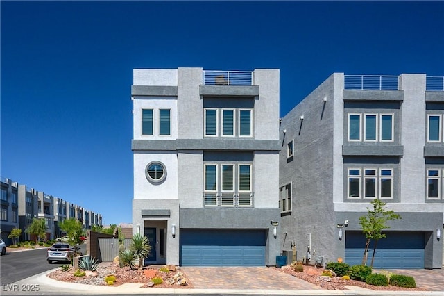 8175 Caldera Creek St, Las Vegas, NV 89113 - contemporary home featuring a garage, stucco siding, and decorative driveway