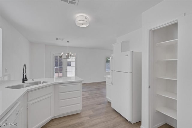 3741 Cactus Wheel Ct, Las Vegas, NV 89129 - kitchen with white appliances, a chandelier, white cabinetry, a peninsula, and light wood-style flooring