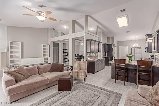 1761 Summerwood Cir, Henderson, NV 89012 - living room featuring lofted ceiling, a chandelier, a ceiling fan, and light wood-style floors