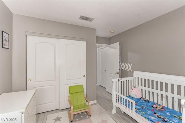 1761 Summerwood Cir, Henderson, NV 89012 - bedroom featuring a closet, light wood-style flooring, and a crib