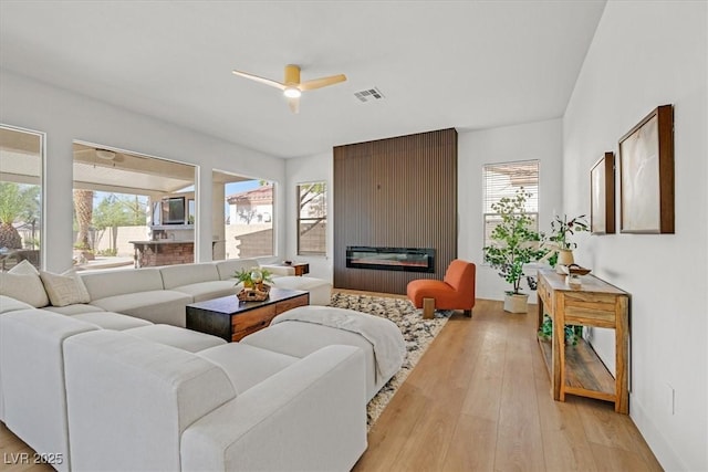 328 Hedgehope Dr, Las Vegas, NV 89183 - living room featuring a ceiling fan, a fireplace, and light wood finished floors