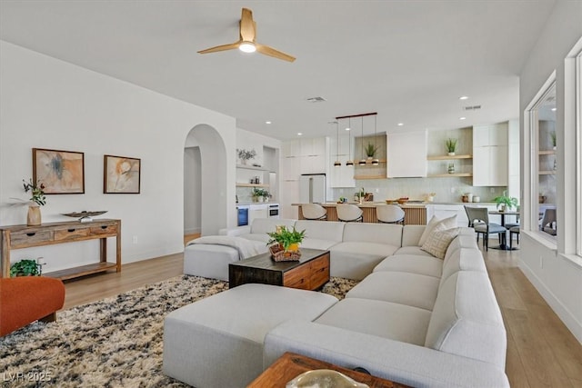 328 Hedgehope Dr, Las Vegas, NV 89183 - living room with arched walkways, light wood-style floors, ceiling fan, and recessed lighting