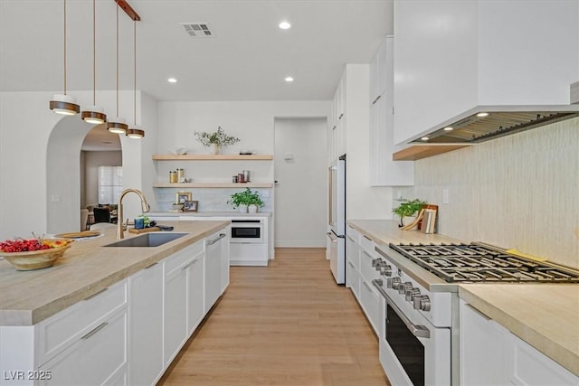 328 Hedgehope Dr, Las Vegas, NV 89183 - kitchen with white appliances, custom exhaust hood, arched walkways, backsplash, and open shelves