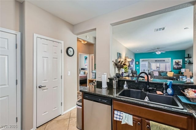 7717 Pine Warbler Way N, Las Vegas, NV 89084 - kitchen with stainless steel dishwasher, light tile patterned floors, a ceiling fan, open floor plan, and dark stone countertops