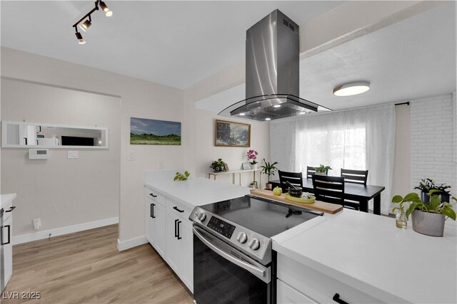 3509 Navajo Way, Las Vegas, NV 89108 - kitchen featuring stainless steel electric stove, island exhaust hood, and light countertops