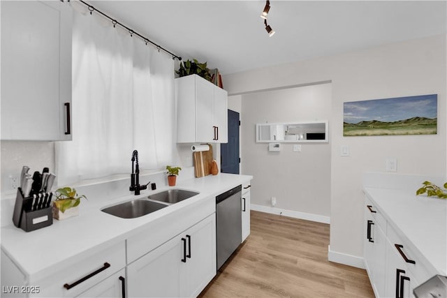 3509 Navajo Way, Las Vegas, NV 89108 - kitchen with stainless steel dishwasher, white cabinets, light countertops, and light wood-style flooring