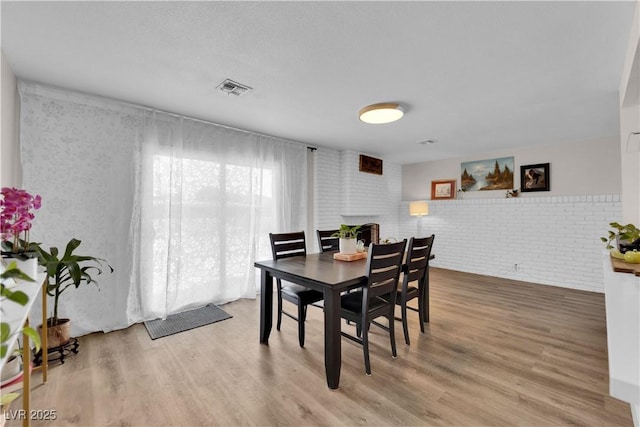 3509 Navajo Way, Las Vegas, NV 89108 - dining area with wood finished floors and brick wall