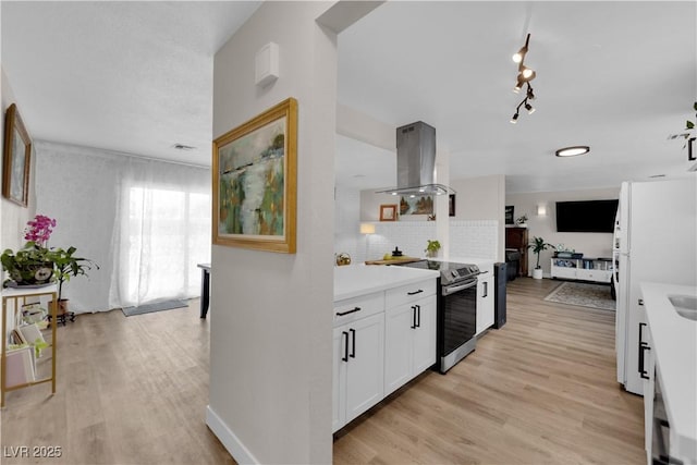 3509 Navajo Way, Las Vegas, NV 89108 - kitchen with island range hood, stainless steel electric range oven, decorative backsplash, light countertops, and white cabinets