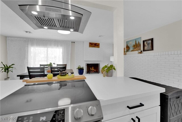 3509 Navajo Way, Las Vegas, NV 89108 - kitchen with stainless steel range with electric cooktop, white cabinets, light countertops, island range hood, and recessed lighting