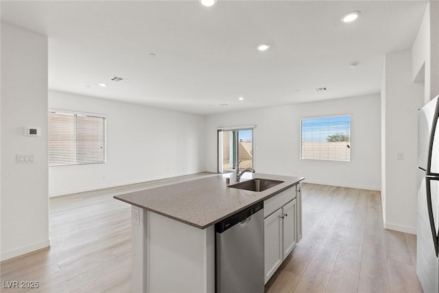 2721 Avril Point St, Las Vegas, NV 89156 - kitchen featuring stainless steel dishwasher, open floor plan, light wood finished floors, an island with sink, and recessed lighting