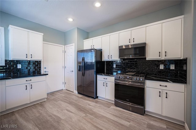 2545 Divine Sky Dr, Henderson, NV 89044 - kitchen featuring appliances with stainless steel finishes, dark countertops, light wood-style flooring, tasteful backsplash, and recessed lighting