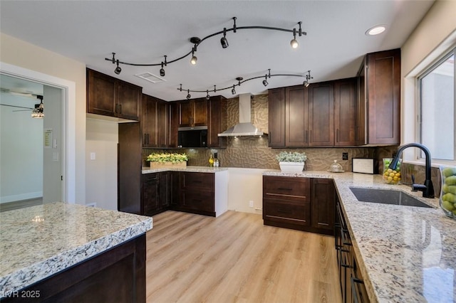 9800 Rosamond Dr, Las Vegas, NV 89134 - kitchen with wall chimney exhaust hood, light stone counters, dark brown cabinets, and light wood-style floors