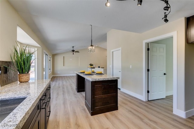 9800 Rosamond Dr, Las Vegas, NV 89134 - kitchen with light wood-type flooring, ceiling fan, a center island, dark brown cabinets, and hanging light fixtures