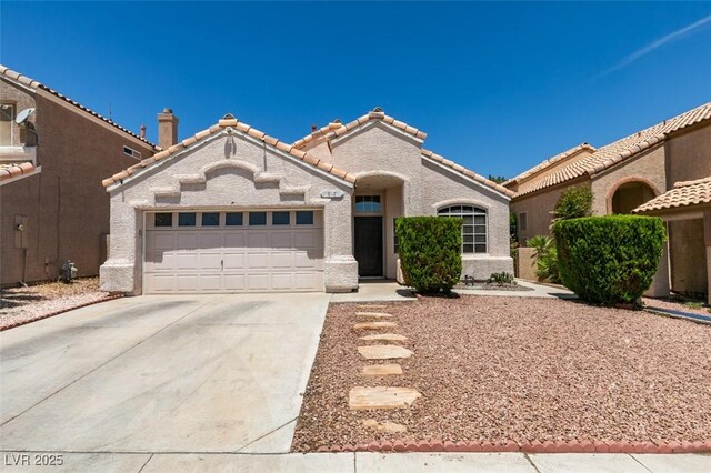 87 Ginger Lily Ter, Henderson, NV 89074 - mediterranean / spanish house with concrete driveway, an attached garage, stucco siding, and a tile roof
