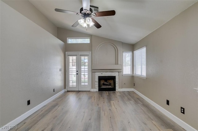 87 Ginger Lily Ter, Henderson, NV 89074 - unfurnished living room featuring vaulted ceiling, a ceiling fan, light wood-style floors, a fireplace, and french doors