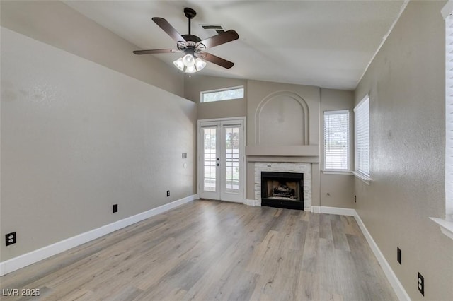 87 Ginger Lily Ter, Henderson, NV 89074 - unfurnished living room with healthy amount of natural light, a ceiling fan, wood finished floors, a fireplace, and vaulted ceiling