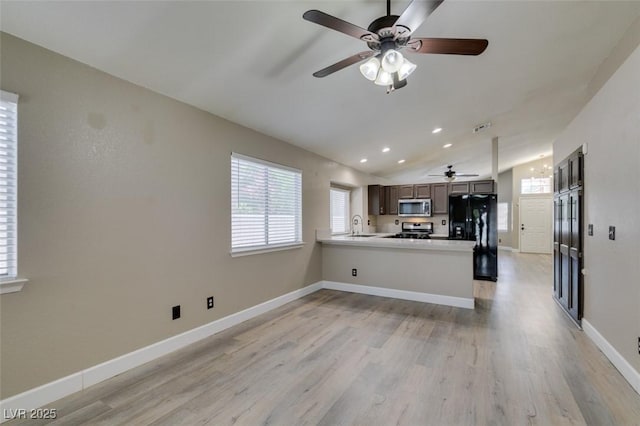 87 Ginger Lily Ter, Henderson, NV 89074 - kitchen featuring stainless steel microwave, range, ceiling fan, black fridge, and light wood-style floors