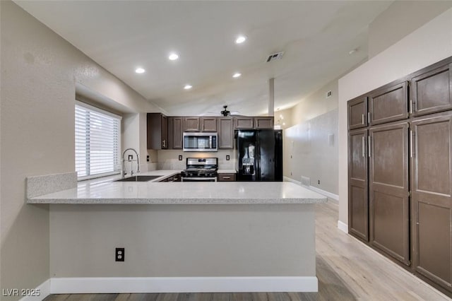 87 Ginger Lily Ter, Henderson, NV 89074 - kitchen with stainless steel appliances, a ceiling fan, a peninsula, light wood-type flooring, and dark brown cabinets