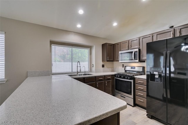 87 Ginger Lily Ter, Henderson, NV 89074 - kitchen featuring appliances with stainless steel finishes, light countertops, recessed lighting, light wood finished floors, and dark brown cabinetry