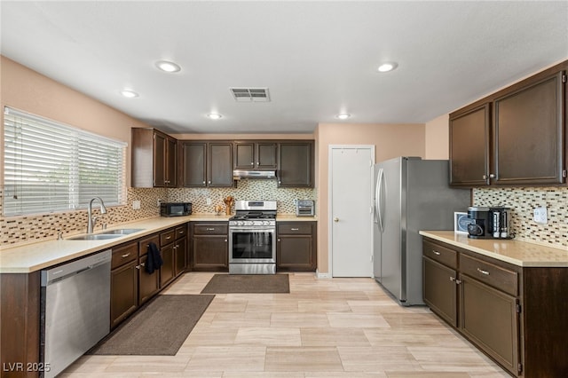 10253 Martinsburg Ct, Las Vegas, NV 89183 - kitchen with stainless steel appliances, dark brown cabinets, tasteful backsplash, light countertops, and recessed lighting