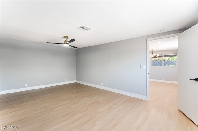 915 Melrose Dr, Las Vegas, NV 89101 - empty room featuring light wood finished floors, a chandelier, and a ceiling fan
