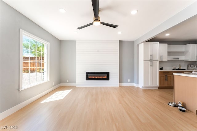 915 Melrose Dr, Las Vegas, NV 89101 - unfurnished living room featuring ceiling fan, light wood finished floors, recessed lighting, and a fireplace