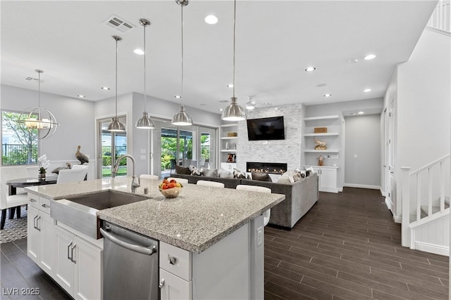 6338 Skystone St, Las Vegas, NV 89135 - kitchen with stainless steel dishwasher, healthy amount of natural light, a large fireplace, dark wood-style floors, and recessed lighting