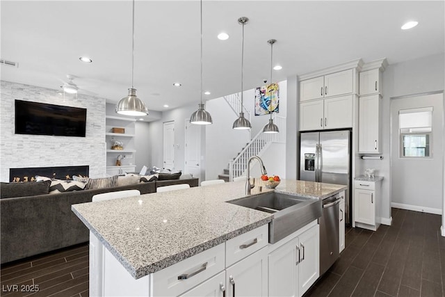 6338 Skystone St, Las Vegas, NV 89135 - kitchen with dark wood-type flooring, appliances with stainless steel finishes, open floor plan, recessed lighting, and white cabinets