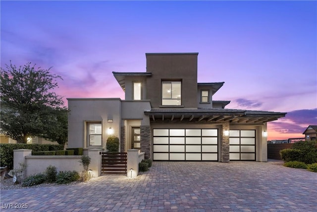 6338 Skystone St, Las Vegas, NV 89135 - modern home featuring a fenced front yard, driveway, an attached garage, stucco siding, and stone siding