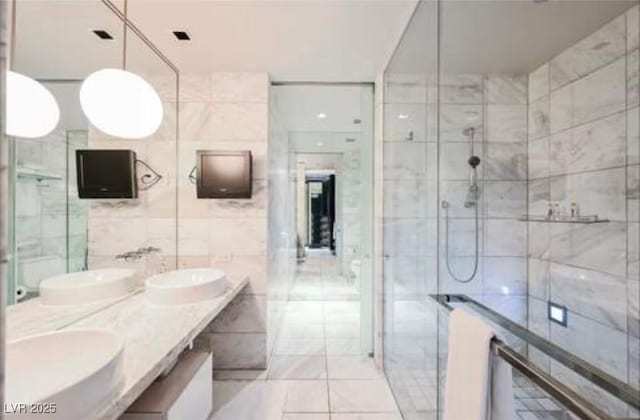 4381 W Flamingo Rd Unit 2902, Las Vegas, NV 89103 - bathroom featuring double vanity, tile walls, a shower stall, and tile patterned floors