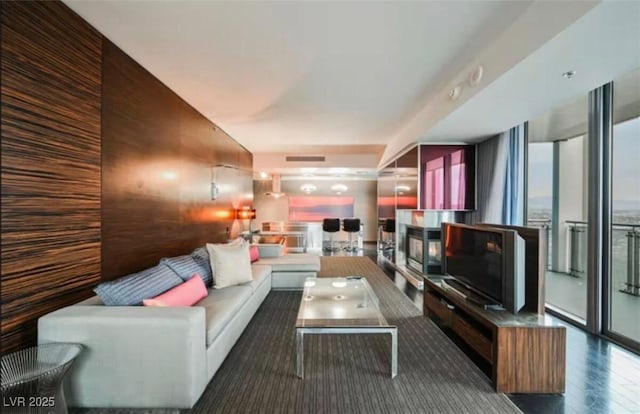 4381 W Flamingo Rd Unit 2902, Las Vegas, NV 89103 - living area with a multi sided fireplace, wood finished floors, and wood walls