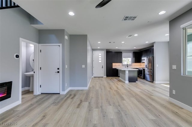 649 Tranquil Jade St, Las Vegas, NV 89138 - kitchen with appliances with stainless steel finishes, light countertops, a kitchen island with sink, open floor plan, and light wood-style floors