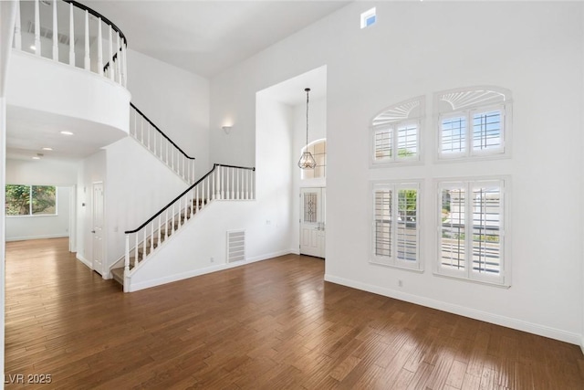 8113 Blue Cascade Ave, Las Vegas, NV 89128 - unfurnished living room with a towering ceiling, stairs, and wood finished floors