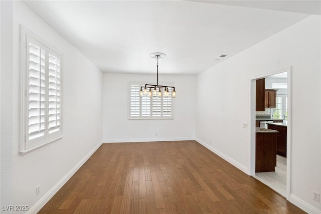8113 Blue Cascade Ave, Las Vegas, NV 89128 - unfurnished dining area featuring a chandelier and dark wood finished floors