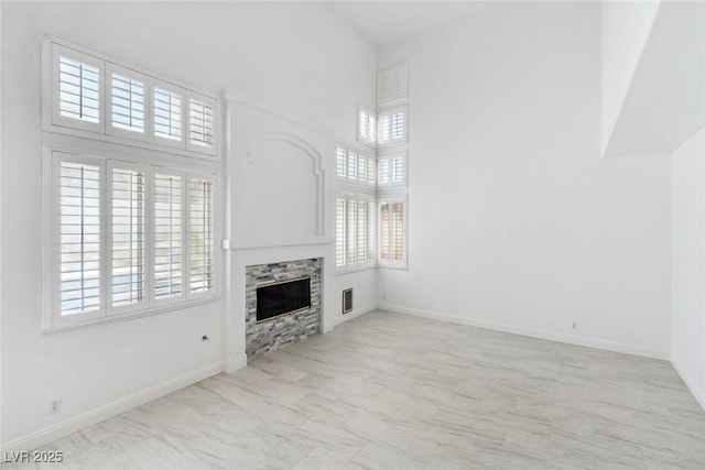 8113 Blue Cascade Ave, Las Vegas, NV 89128 - unfurnished living room featuring a glass covered fireplace and a towering ceiling