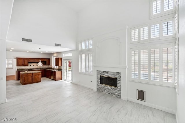 8113 Blue Cascade Ave, Las Vegas, NV 89128 - unfurnished living room with a towering ceiling, a glass covered fireplace, and light marble finish floors