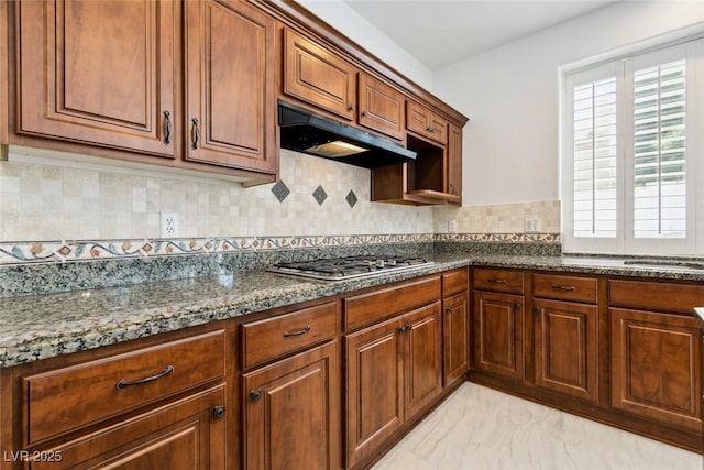8113 Blue Cascade Ave, Las Vegas, NV 89128 - kitchen featuring stainless steel gas cooktop, under cabinet range hood, healthy amount of natural light, and dark stone countertops