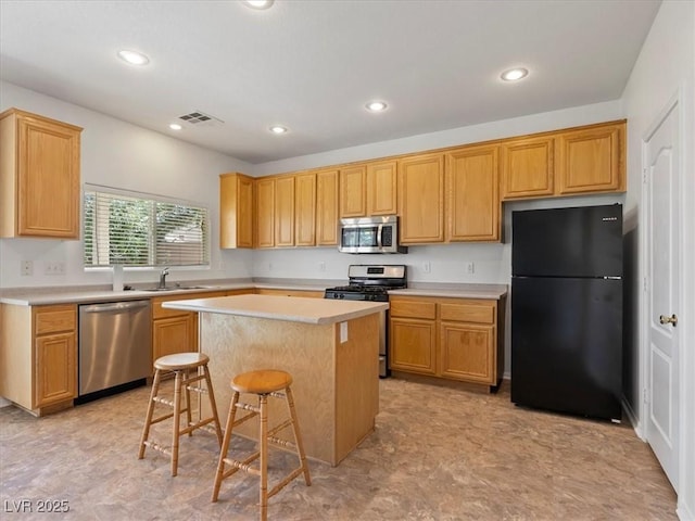 4905 Apache Valley Ave, Las Vegas, NV 89131 - kitchen with appliances with stainless steel finishes, light countertops, a center island, a kitchen bar, and recessed lighting