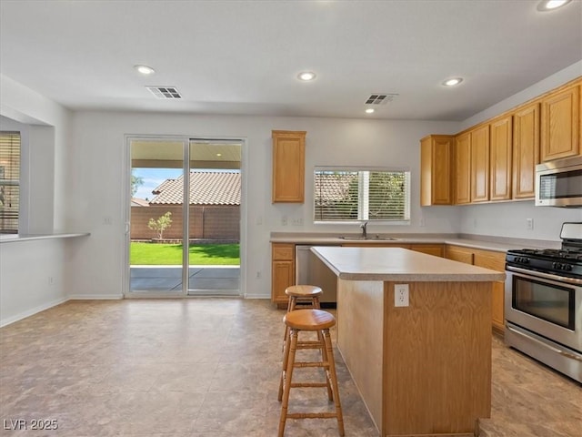 4905 Apache Valley Ave, Las Vegas, NV 89131 - kitchen featuring stainless steel appliances, light countertops, a kitchen island, healthy amount of natural light, and recessed lighting