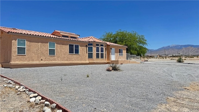 2530 Commercial Dr, Pahrump, NV 89048 - rear view of property featuring a mountain view, a tile roof, and stucco siding