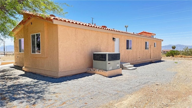 2530 Commercial Dr, Pahrump, NV 89048 - view of side of property featuring a mountain view, a tiled roof, and stucco siding