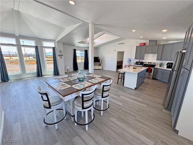 2530 Commercial Dr, Pahrump, NV 89048 - dining room with lofted ceiling, light wood finished floors, a textured ceiling, and recessed lighting