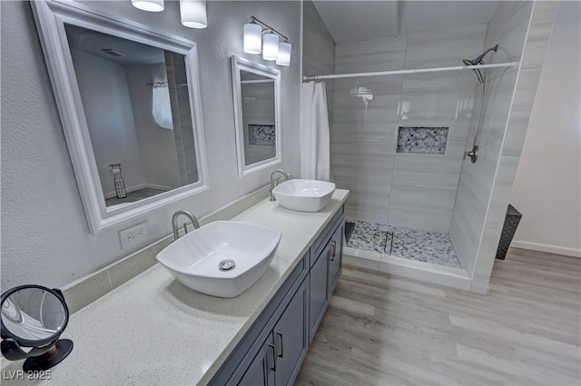 2530 Commercial Dr, Pahrump, NV 89048 - bathroom featuring a tile shower, double vanity, and wood finished floors