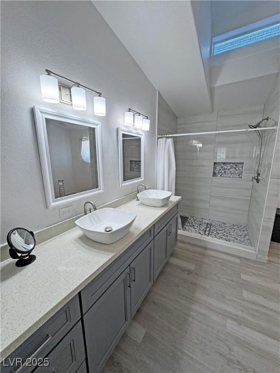 2530 Commercial Dr, Pahrump, NV 89048 - full bathroom featuring a stall shower, double vanity, wood finished floors, and vaulted ceiling