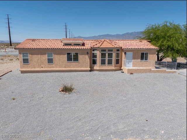 2530 Commercial Dr, Pahrump, NV 89048 - view of front of house with stucco siding, a tiled roof, and a mountain view